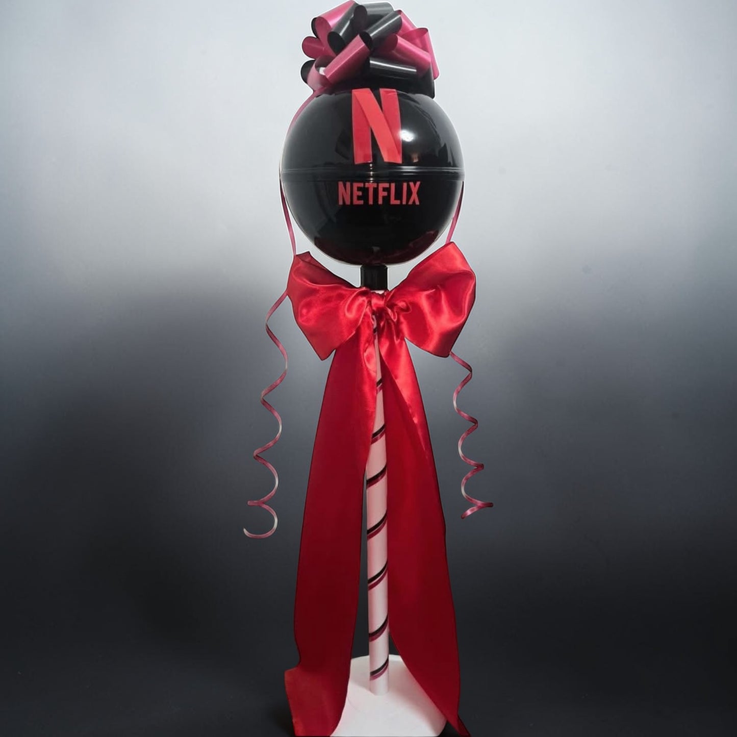 Decorative balloon with Netflix logo and red ribbon on a gray background