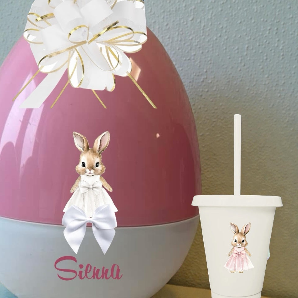Decorative Easter egg with a rabbit design and a matching cup on a neutral background