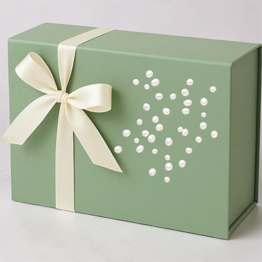 Green gift box with a white ribbon and decorative heart made of pearls on a light gray background