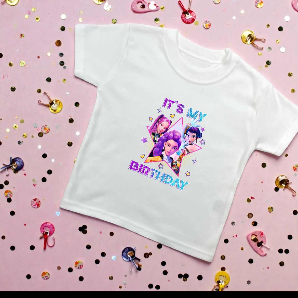 White t-shirt with colorful graphic and text on a pink background with confetti