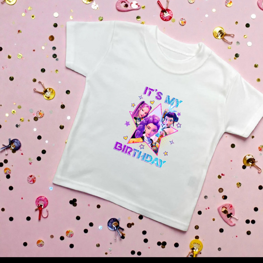 White t-shirt with colorful graphic and text on a pink background with confetti