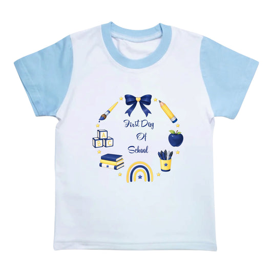 A kids' short-sleeve raglan t-shirt with a white body and light blue sleeves, featuring a 'First Day Of School' school supplies graphic in blue and yellow.
