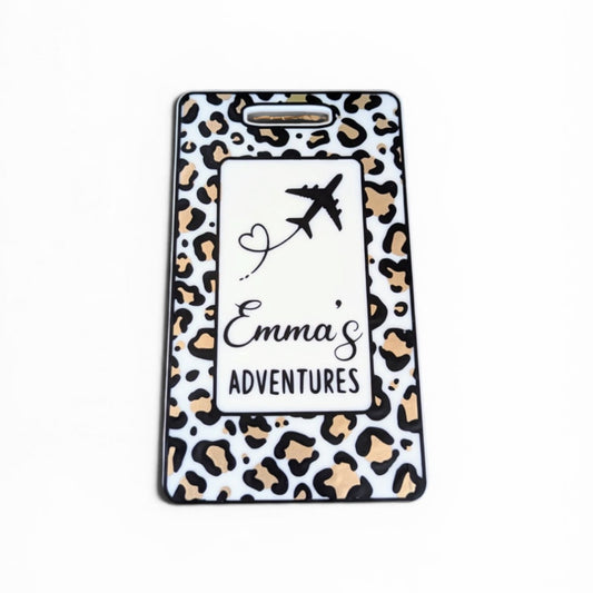 Leopard print luggage tag with 'Emma's Adventures' text and airplane design on a white background