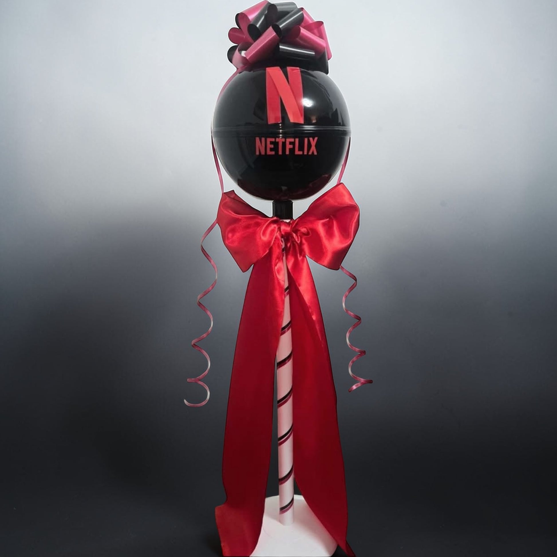 Decorative balloon with Netflix logo and red ribbon on a gray background